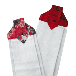Two white hanging kitchen towels with decorative red and black floral fabric tops and button closures.